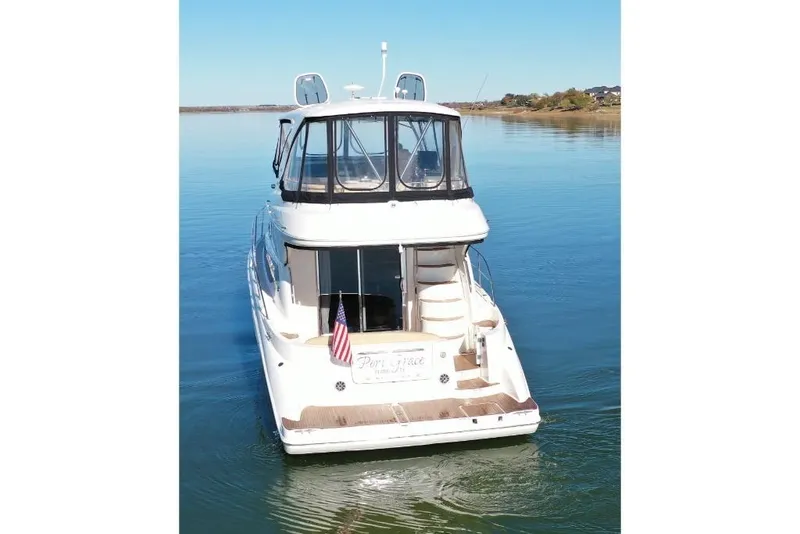 Slide: The Image of 2016 Meridian 441 yacht on calm water, rear view with American flag. - 8