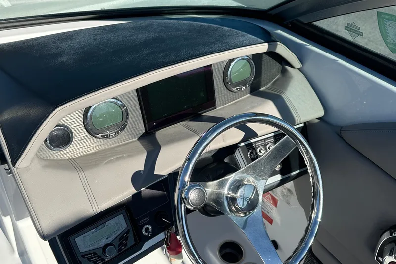 Slide: The Image of 2022 Four Winns HD5 OB boat dashboard with steering wheel and gauges. - 15
