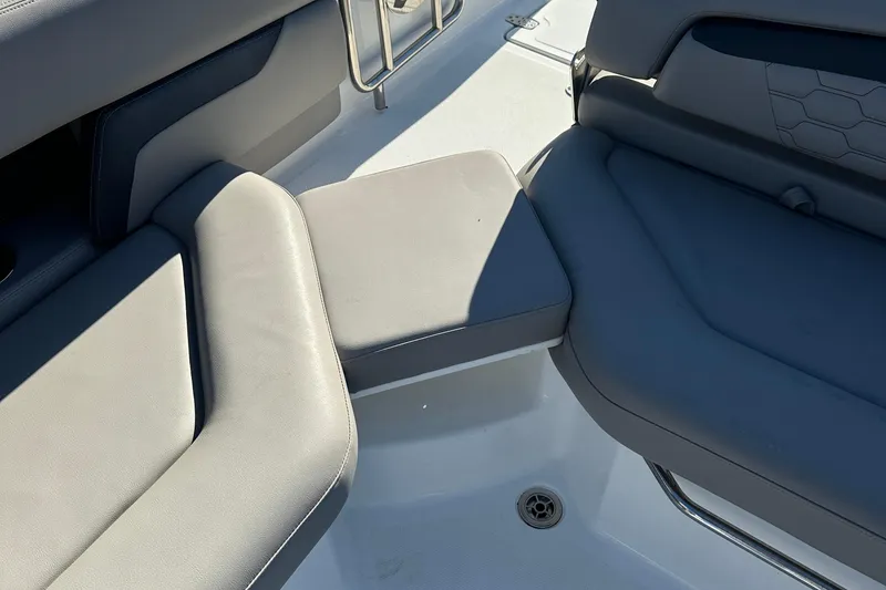 Slide: The Image of 2022 Four Winns HD5 OB boat interior with gray cushioned seating and stainless steel accents. - 18