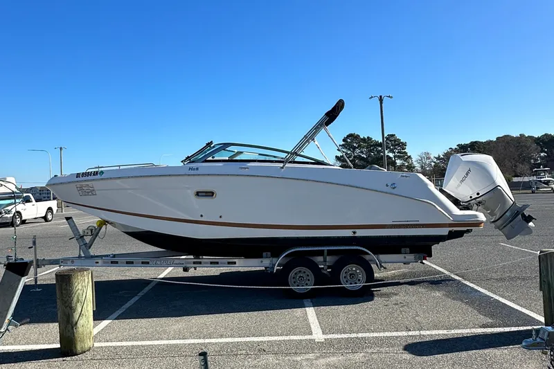 Slide: The Image of 2022 Four Winns HD5 OB boat on trailer in parking lot under clear blue sky. - 5