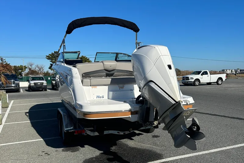 Slide: The Image of 2022 Four Winns HD5 OB boat with outboard motor in a parking lot. - 6