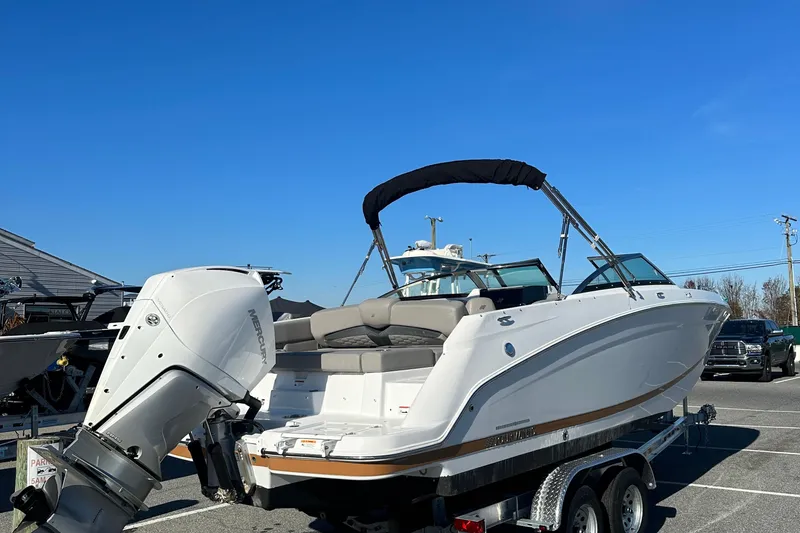 Slide: The Image of 2022 Four Winns HD5 OB boat on trailer with outboard motor, under clear blue sky. - 8