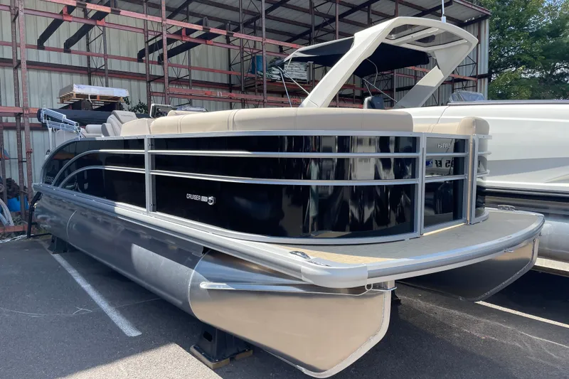 The Image of 2026 Harris Cruiser 210 CW pontoon boat in storage, featuring sleek design and modern amenities. - 0