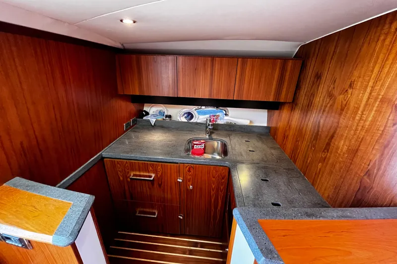 Slide: The Image of 2009 Tiara Yachts 3900 Open galley with wood cabinetry and sleek countertops. - 20