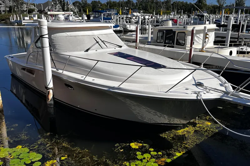 Slide: The Image of 2009 Tiara Yachts 3900 Open docked in a marina, surrounded by other boats. - 3