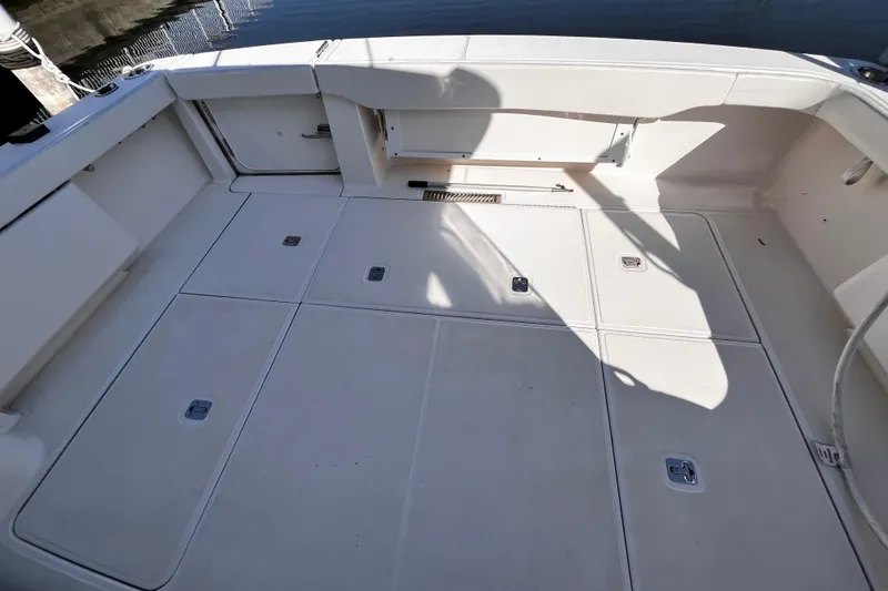 Slide: The Image of 2009 Tiara Yachts 3900 Open boat deck with storage compartments, docked by water. - 5