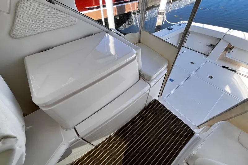 Slide: The Image of 2009 Tiara Yachts 3900 Open cockpit with seating and storage, docked by the water. - 8