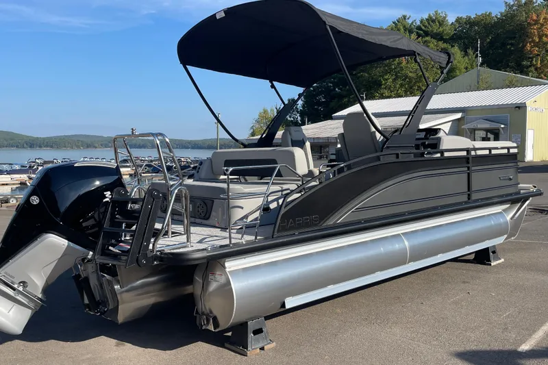 Slide: The Image of 2026 Harris Solstice 230SLDH pontoon boat with canopy, docked near a scenic lake. - 5