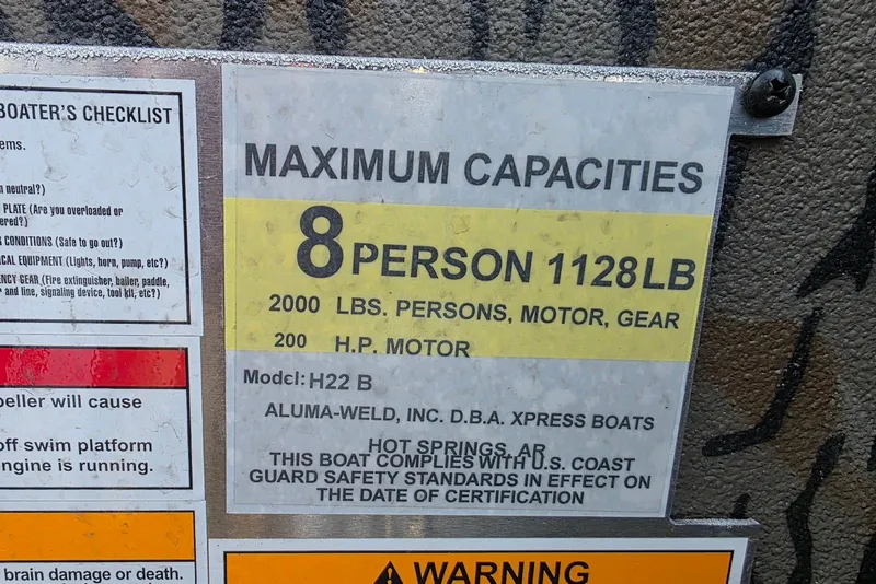 Slide: The Image of Boat capacity label for Xpress H22B Bay, 2026 model, 8 persons, 1128 lbs limit. - 24