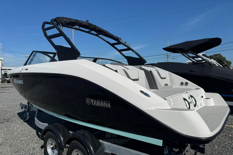 Slide: The Image of 2026 Yamaha Boats AR220, sleek design, black and white exterior, on a trailer, sunny day. - 5