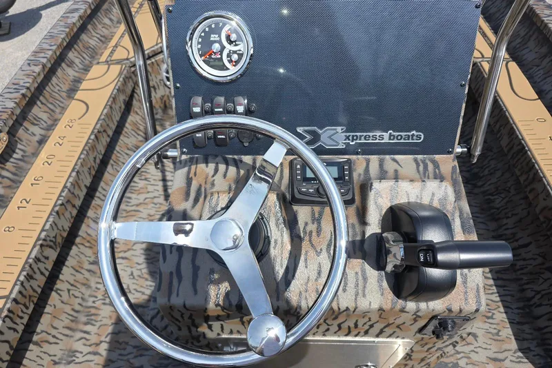 Slide: The Image of Steering console of 2026 Xpress H22B Bay boat with camo design and control panel. - 26