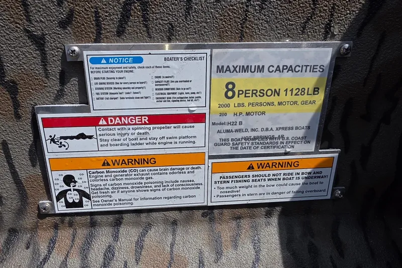 Slide: The Image of Safety and capacity labels on 2026 Xpress H22B Bay boat, warning of propeller and carbon monoxide risks. - 30