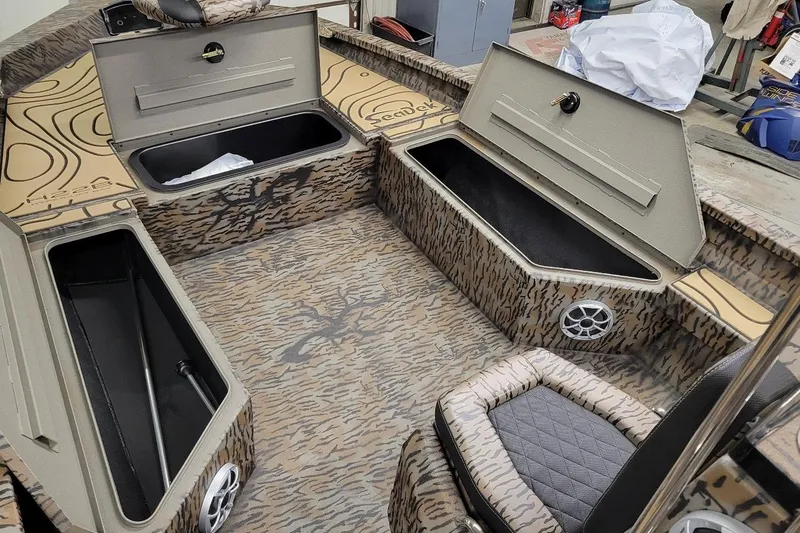 Slide: The Image of 2026 Xpress H22B Bay boat interior with camo design, storage compartments, and seating. - 4
