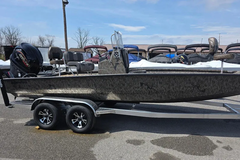 The Image of 2026 Xpress H22B Bay boat on trailer, featuring camo design and powerful outboard motor. - 9