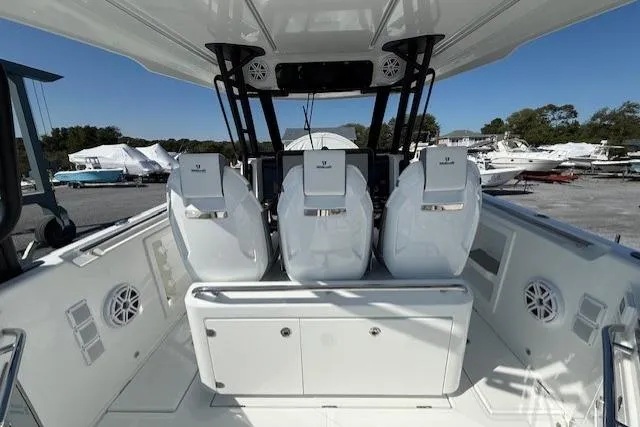 Slide: The Image of 2026 Wellcraft 38 T-Top boat interior with three white seats and modern dashboard. - 10