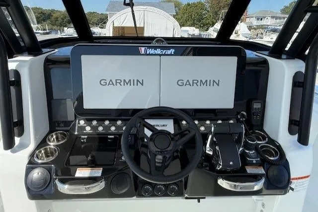 Slide: The Image of 2026 Wellcraft 38 T-Top boat dashboard with dual Garmin displays and steering wheel. - 17
