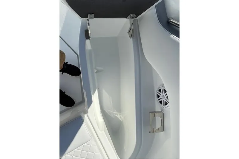 Slide: The Image of 2026 Wellcraft 38 T-Top boat storage compartment with cup holder and speaker. - 24