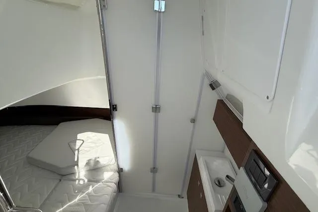 Slide: The Image of Interior of 2026 Wellcraft 38 T-Top boat, featuring a compact cabin with bed and sink. - 31
