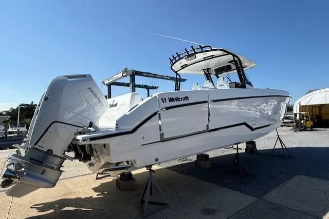 Slide: The Image of 2026 Wellcraft 38 T-Top boat on stands, featuring dual outboard engines. - 4