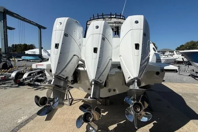 Slide: The Image of 2026 Wellcraft 38 T-Top boat with triple outboard engines, docked at a marina. - 5