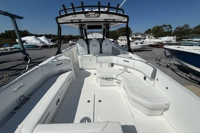 Slide: The Image of 2026 Wellcraft 38 T-Top boat with spacious seating and sleek design in a marina. - 7