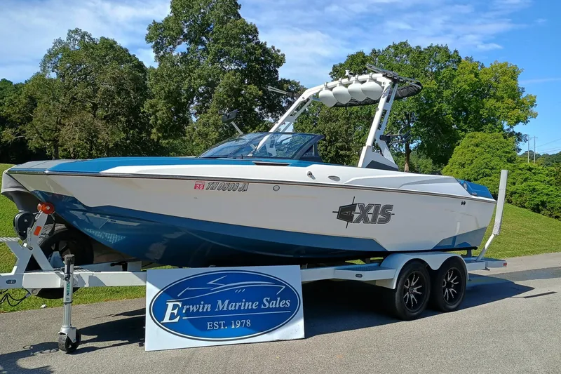Slide: The Image of 2022 Axis A22 boat on trailer at Erwin Marine Sales, surrounded by trees. - 1