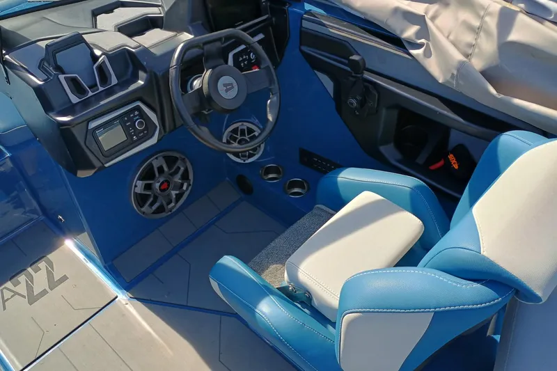 Slide: The Image of 2022 Axis A22 boat interior with blue and white seating, steering wheel, and control panel. - 4