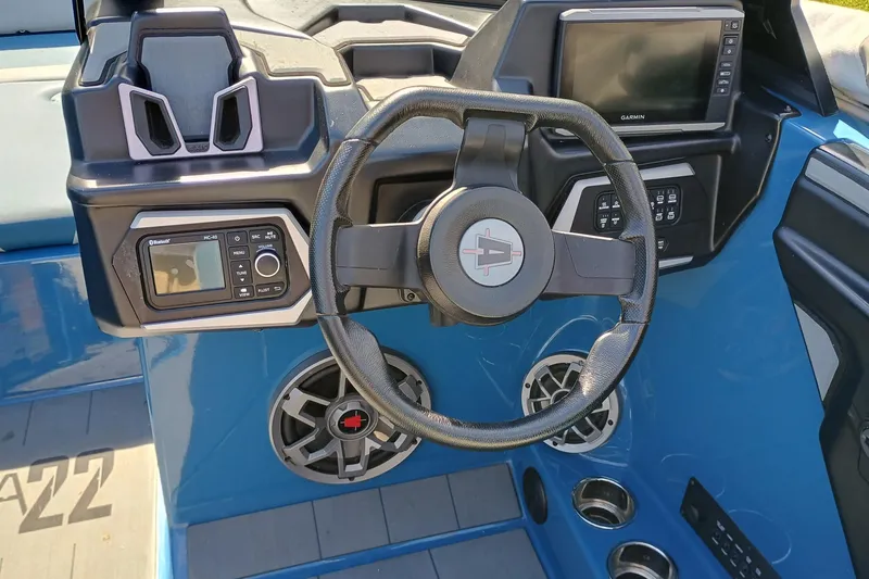 Slide: The Image of 2022 Axis A22 boat dashboard with steering wheel, control panel, and Garmin display. - 5