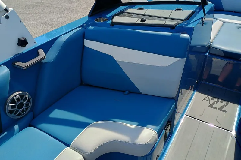 Slide: The Image of 2022 Axis A22 boat interior with blue and white seating and speaker. - 7