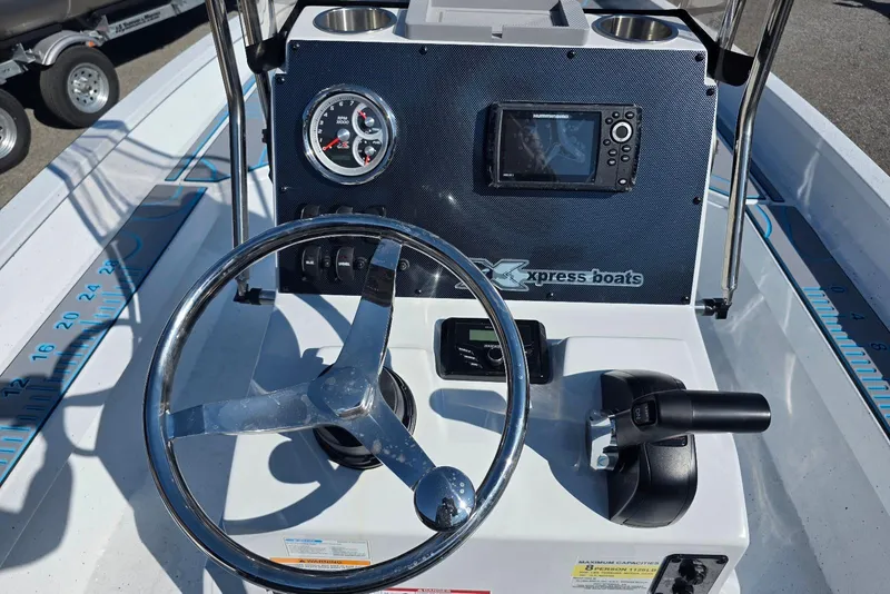 Slide: The Image of 2026 Xpress H22B Bay boat dashboard with steering wheel and navigation controls. - 26