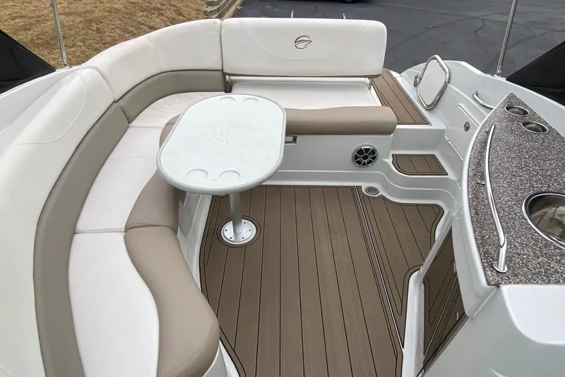 Slide: The Image of 2015 Crownline 305 SS boat interior with seating, table, and kitchenette area. - 11
