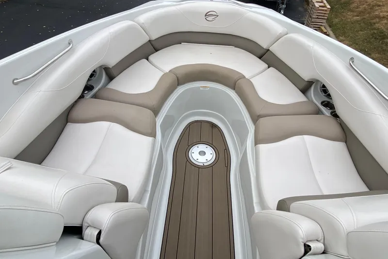 Slide: The Image of 2015 Crownline 305 SS boat interior with beige and white seating, wood-style flooring. - 13
