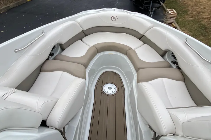 Slide: The Image of 2015 Crownline 305 SS boat interior with beige and white seating, wooden deck. - 14