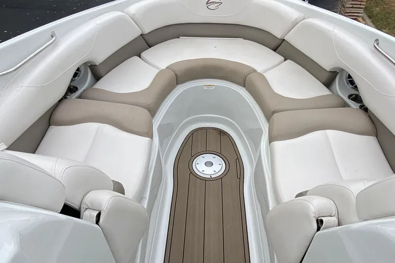 Slide: The Image of 2015 Crownline 305 SS boat interior with beige and white seating, wood-style flooring. - 15