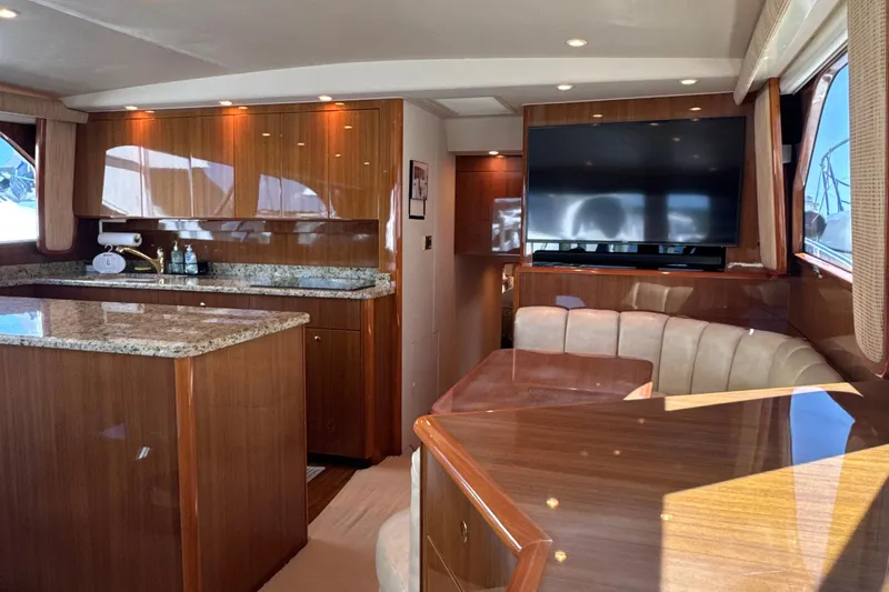 Slide: The Image of Luxurious interior of a 2006 Viking 56 Convertible yacht with granite countertops and plush seating. - 13