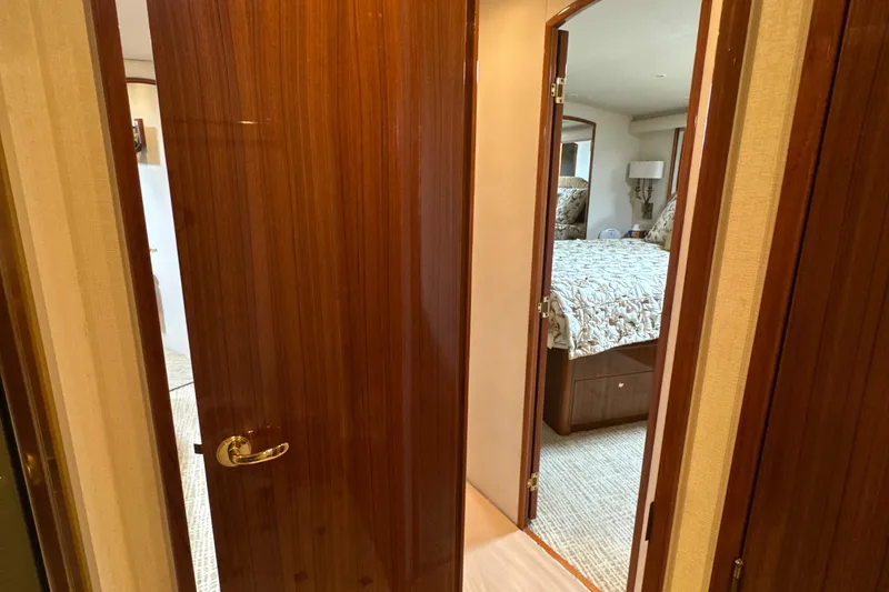 Slide: The Image of Interior view of a 2006 Viking 56 Convertible yacht bedroom with wooden doors. - 26