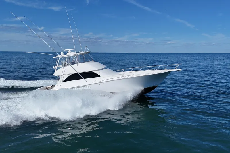 Slide: The Image of 2006 Viking 56 Convertible yacht cruising on open sea under clear blue sky. - 3