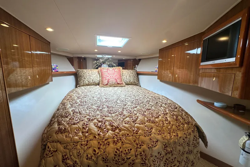 Slide: The Image of Luxurious bedroom interior of 2006 Viking 56 Convertible yacht with elegant bedding and wood cabinetry. - 31