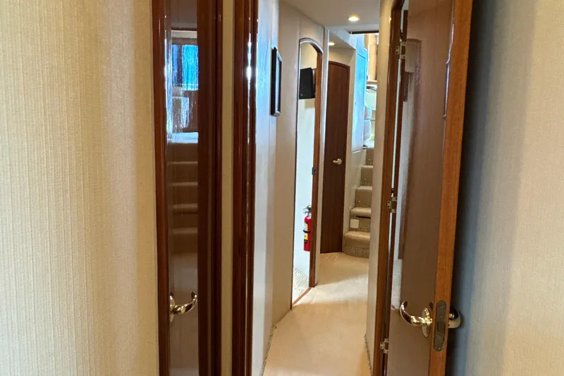 Slide: The Image of Interior hallway of 2006 Viking 56 Convertible yacht with wooden doors and carpeted floor. - 33