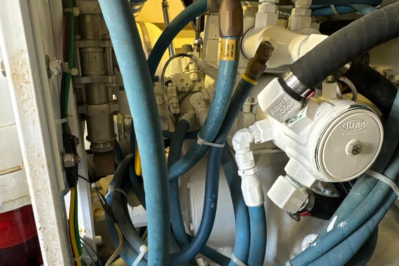 Slide: The Image of Engine room of a 2006 Viking 56 Convertible with hoses and mechanical components. - 58