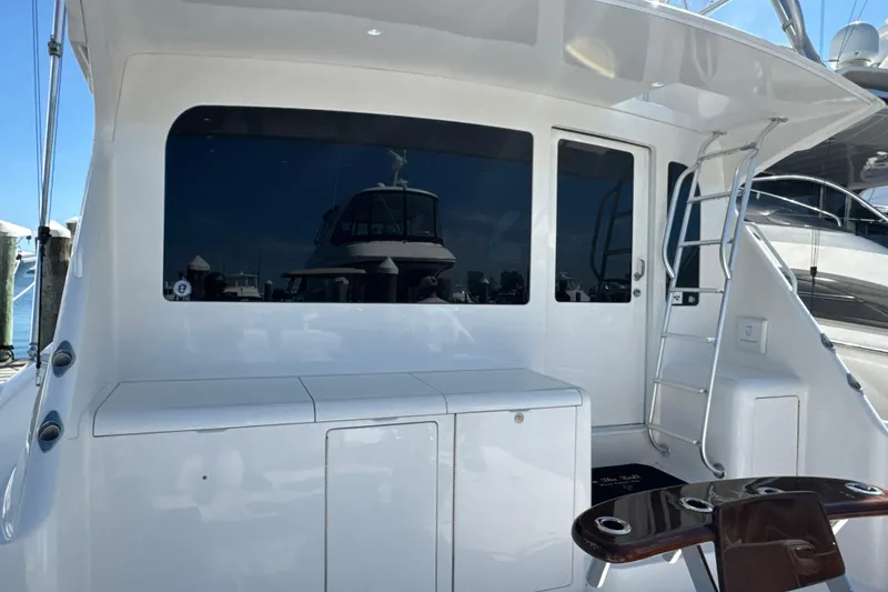 Slide: The Image of 2006 Viking 56 Convertible yacht with sleek white exterior and ladder access. - 62