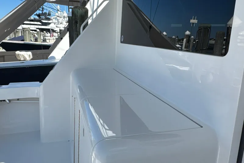 Slide: The Image of 2006 Viking 56 Convertible yacht deck with sleek white finish and marina view. - 65
