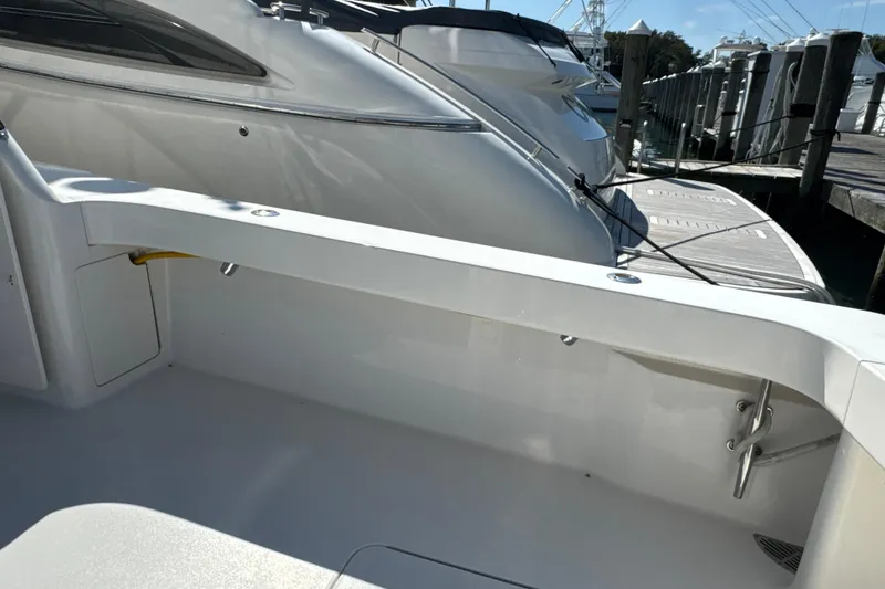 Slide: The Image of 2006 Viking 56 Convertible yacht docked at marina, showcasing sleek design and spacious deck. - 67
