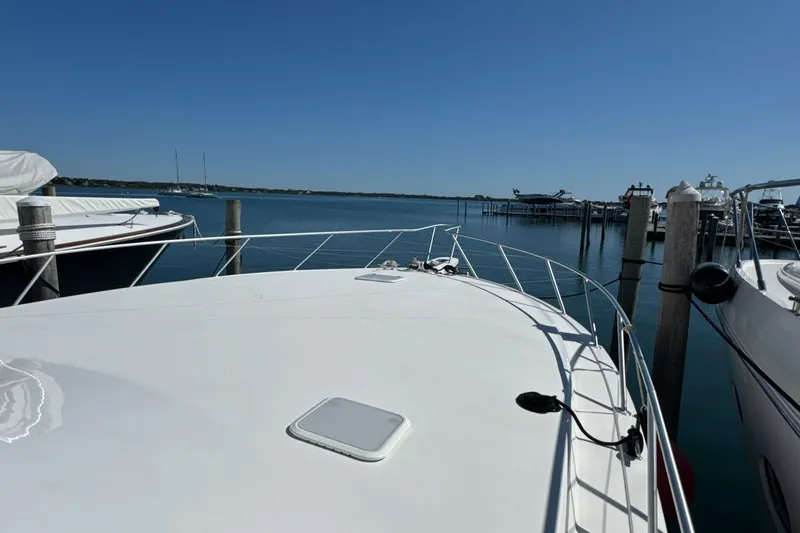 Slide: The Image of 2006 Viking 56 Convertible yacht docked at a marina under clear blue skies. - 69