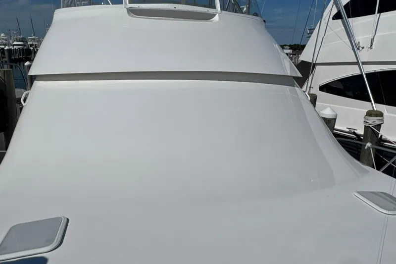 Slide: The Image of 2006 Viking 56 Convertible yacht docked at marina, sleek white exterior. - 70