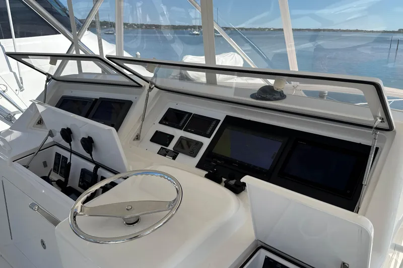 Slide: The Image of 2006 Viking 56 Convertible yacht helm with navigation screens and steering wheel. - 73