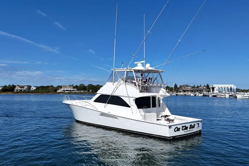 Slide: The Image of 2006 Viking 56 Convertible yacht on calm water under clear blue sky. - 8