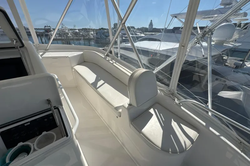 Slide: The Image of 2006 Viking 56 Convertible yacht interior with white seating and marina view. - 80