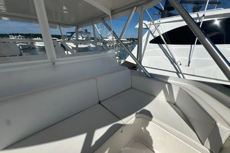 Slide: The Image of 2006 Viking 56 Convertible yacht interior with white seating and marina view. - 82