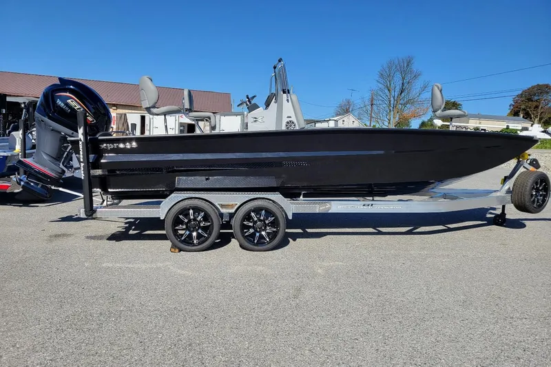 The Image of 2026 Xpress X23B Bay Lounge boat on trailer, sleek black design, outdoor setting. - 1
